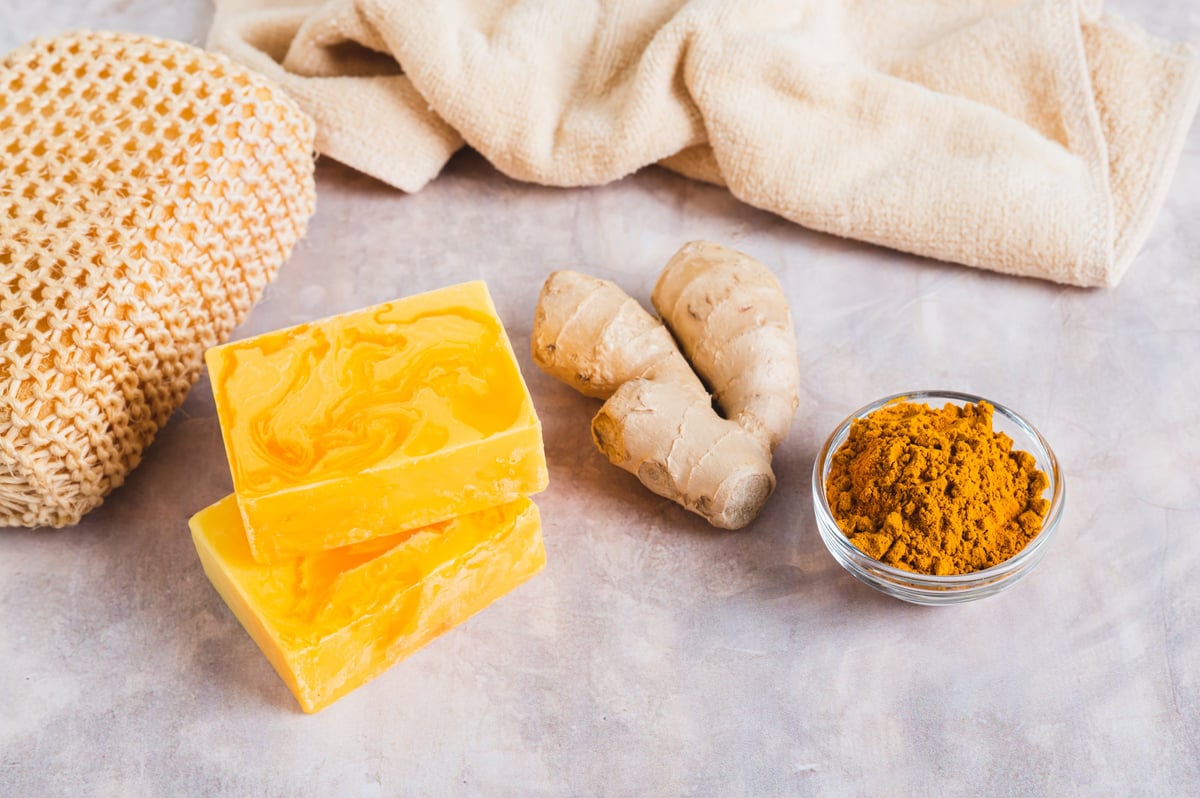 Herbal turmeric soap bars and root on the table