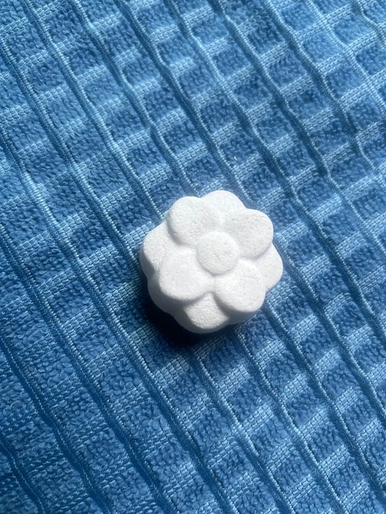 White foam flower shape on blue checkered fabric surface